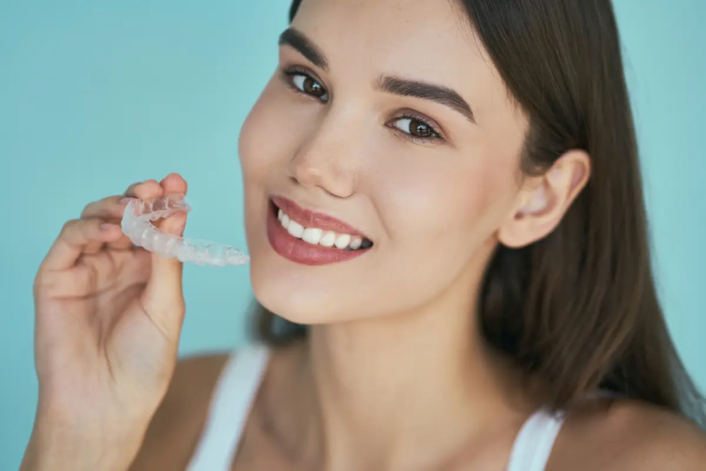 A satisfied orthodontic patient shows how her Invisalign clear braces straightened her smile.