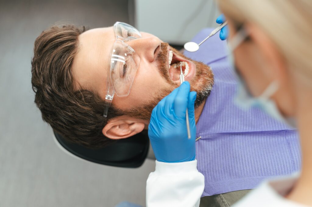 Dentist examining a patient for tooth sensitivity in Alexandria, VA