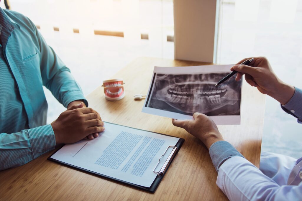 Dentist explaining effects of missing tooth and bone loss to patient in Alexandria VA